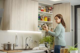 Woman stocking up her pantry with healthy pantry staples