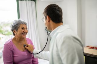 Doctor checking on a senior patient's heart