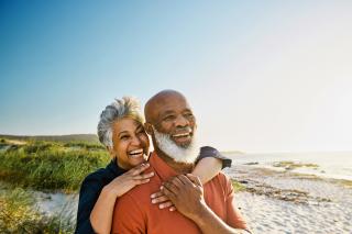 Couple embracing and smiling on beach shore