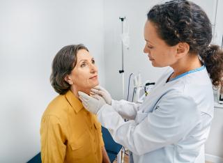 Medical professional examining patient's neck